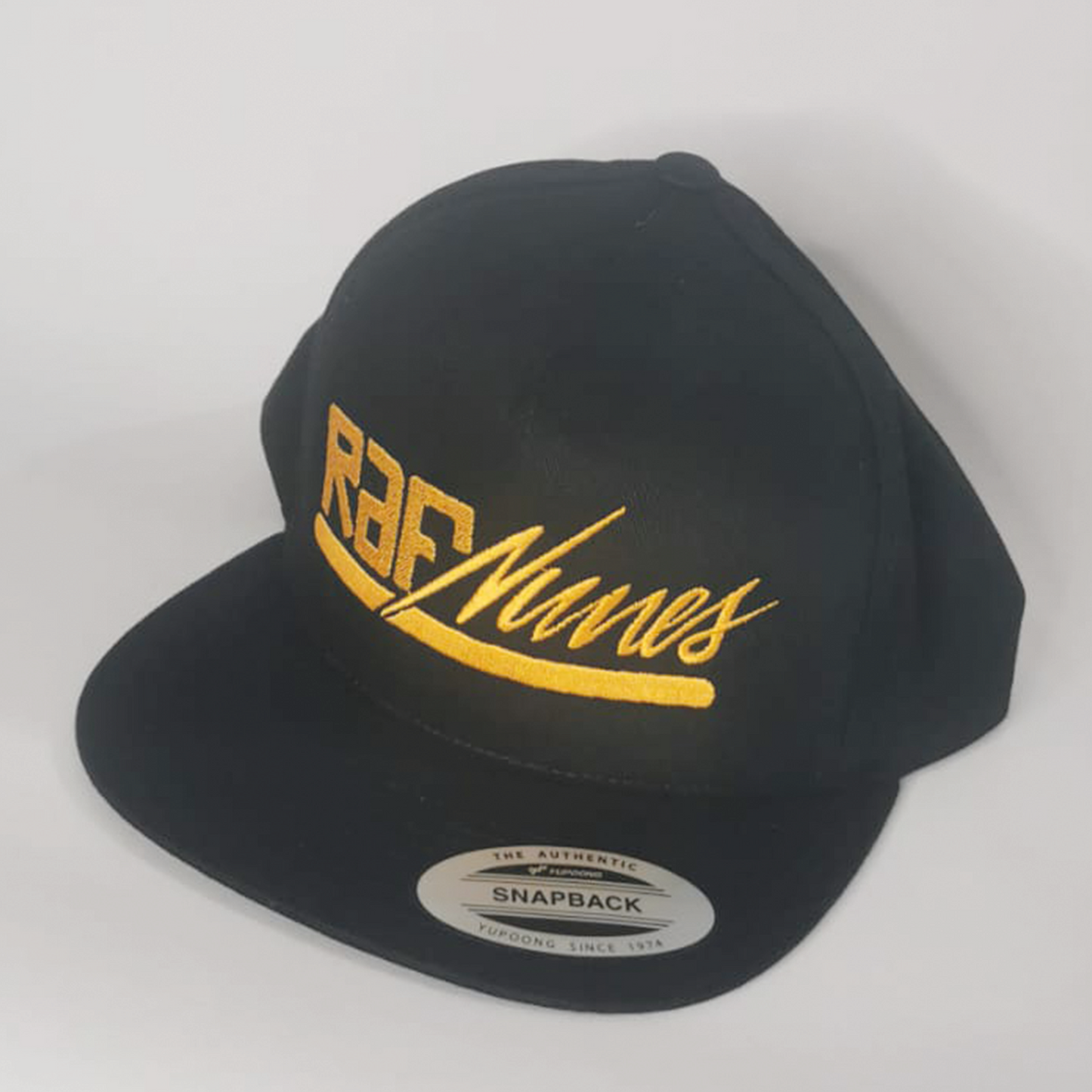 Boné snapback com ajuste parte traseira, preto e bordado dourado